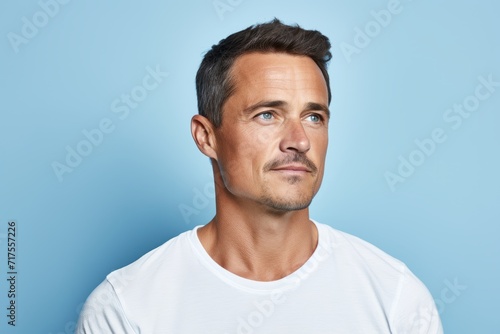 Handsome man in white t-shirt on blue background.