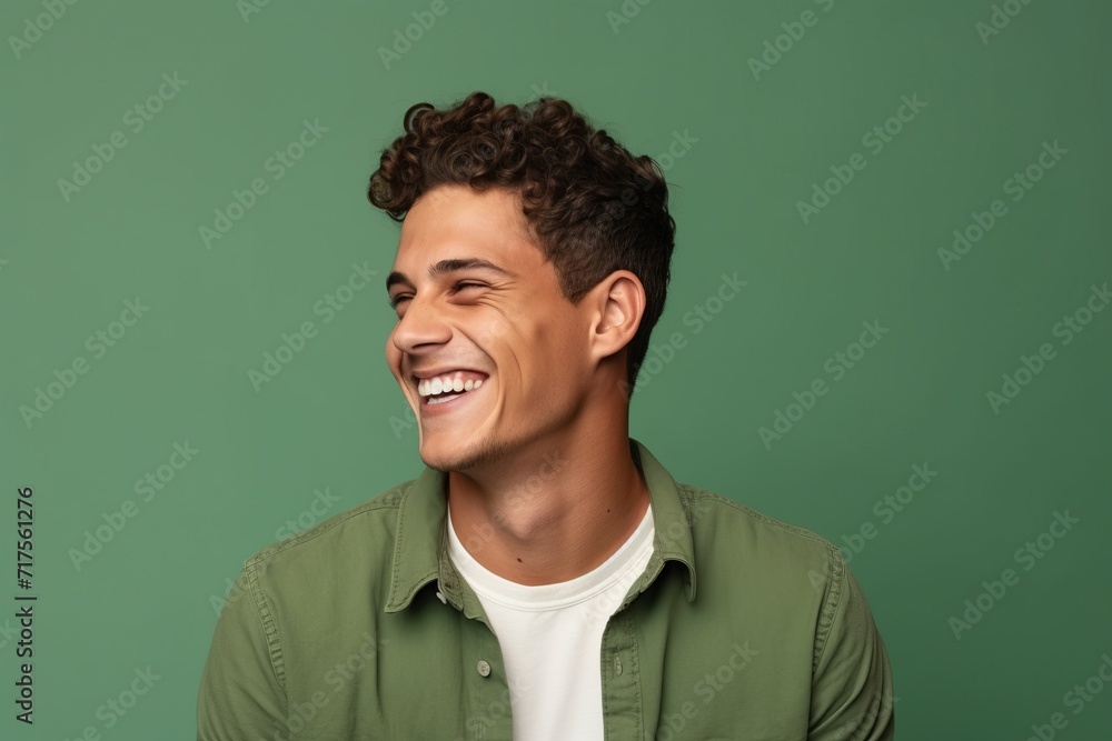Portrait of handsome young man laughing and looking at camera isolated over green background Portrait of handsome young man laughing and looking at camera isolated over green background