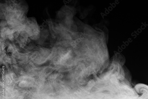 Blur white water vapour on isolated black background. Abstract of steam with copy space.  Smoke on black background. Steam flow. photo