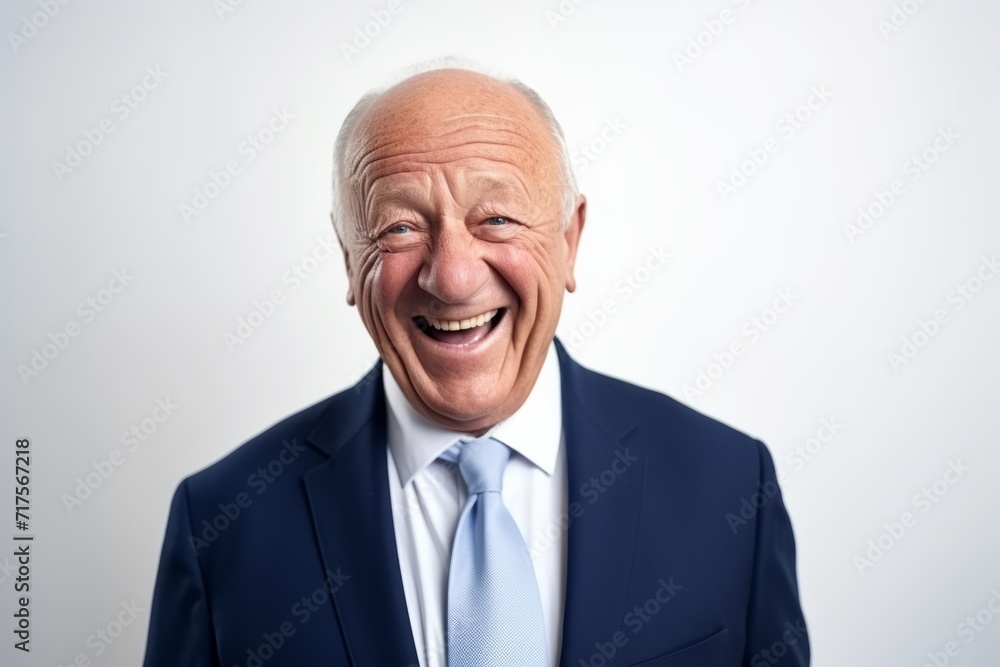Elderly businessman laughing and looking at the camera on a gray background Elderly businessman laughing and looking at the camera on a gray background