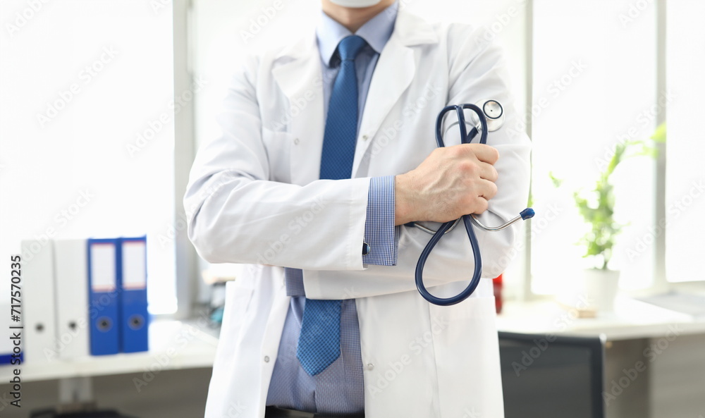 Doctor standing in office with stethoscope in his hand. Platform for online consultation with doctors. Family doctor appointment online. Pandemic disease prevention. Elucidation medical history