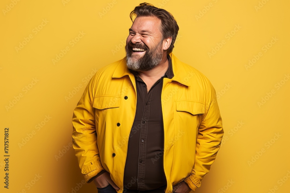 Portrait of a smiling bearded man in a yellow jacket on a yellow background Portrait of a smiling bearded man in a yellow jacket on a yellow background