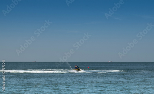 A man riding a jet ski on the beach in the Gulf of Mexico. embodying the essence of a thrilling summer water sport adventure by the coast. © nongnuch