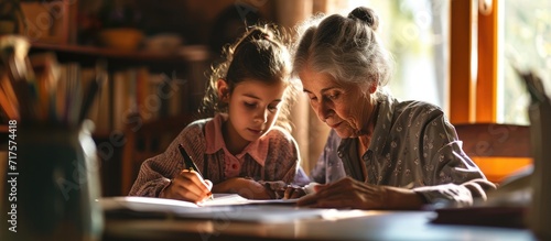 grandmother teaching granddaughter and helping her with homework at home. Copy space image. Place for adding text or design