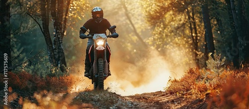 Motorcycle balance and motion blur with a man at a race on space in the forest for dirt biking Bike fitness and power with a sports person driving fast on an off road course for freedom or spee photo