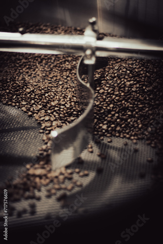 Close up of beans in a stainless steel industrial coffee roaster for an artisan coffee maker.
