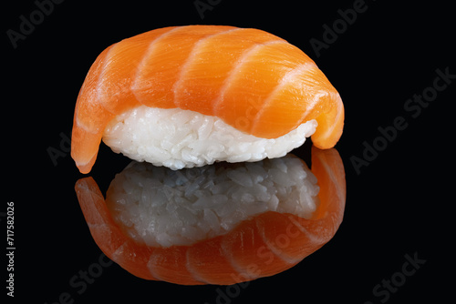 Composition of fresh salmon sashimi sushi isolated on a black background with reflect.Snow white rice.Menu of sushi bar, restaurant.