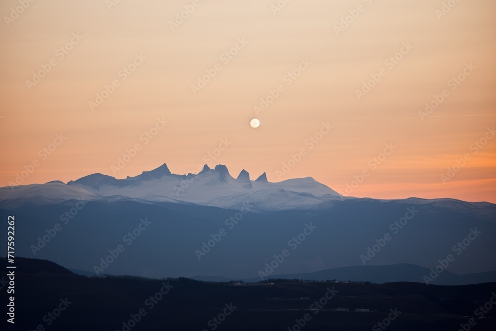 partial lunar eclipse above silhouetted mountains
