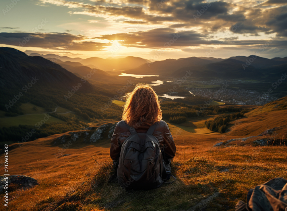 Hiker with backpack enjoying sunset view overlooking lake i