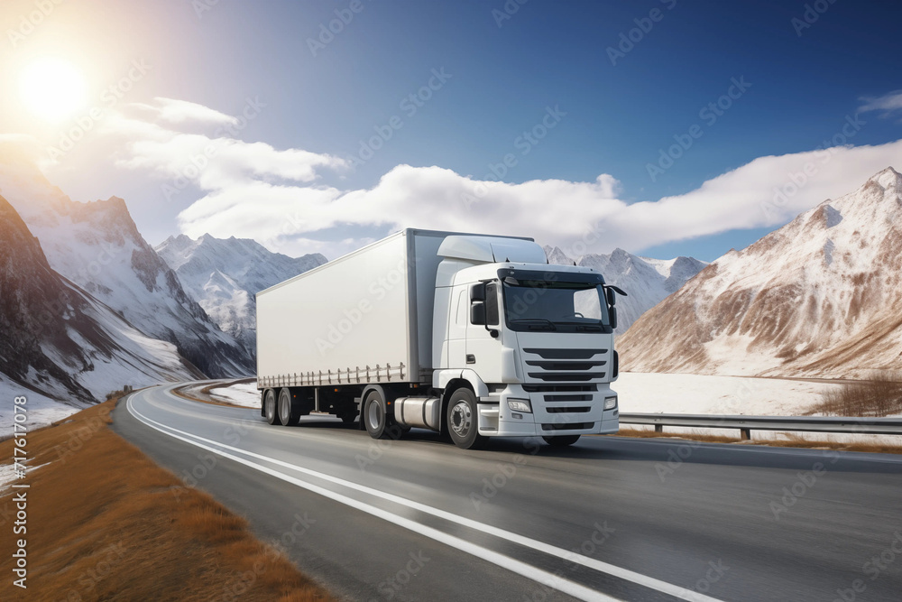 Obraz premium a white cargo truck with a white blank empty trailer for ad on a highway road, beautiful nature mountains and sky. driving in motion