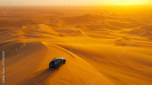 a modern car traversing the vast expanse of a golden desert landscape. The car, sleek in design, creates a striking contrast with the endless, undulating dunes bathed in the warm, amber sun. © Christian