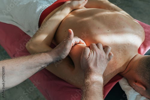 Massage therapist gives massage to patient, close-up. Wellness and revitalization massage and spa treatments. photo