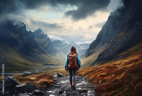 a woman wandering in the mountains in her backpack photo
