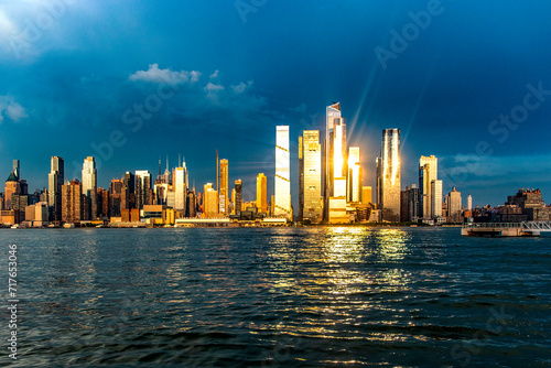 Wonderful skyline of New York and Big Apple seen from a viewpoint on the Hudson River  under a sunset and the sun s rays reflecting on the buildings.