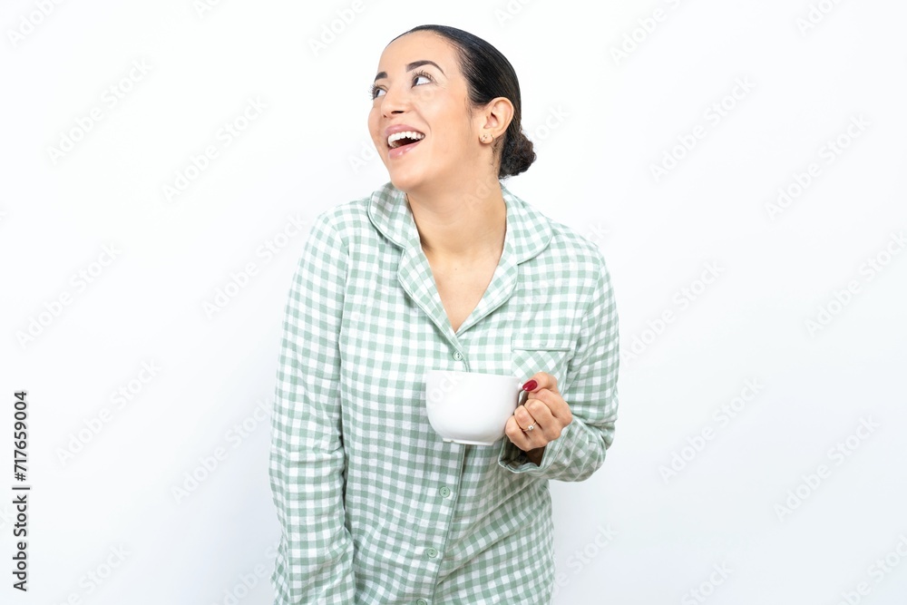 Beautiful young woman wearing green plaid pyjama very happy and excited about new plans. Beautiful young woman wearing green plaid pyjama very happy and excited about new plans.