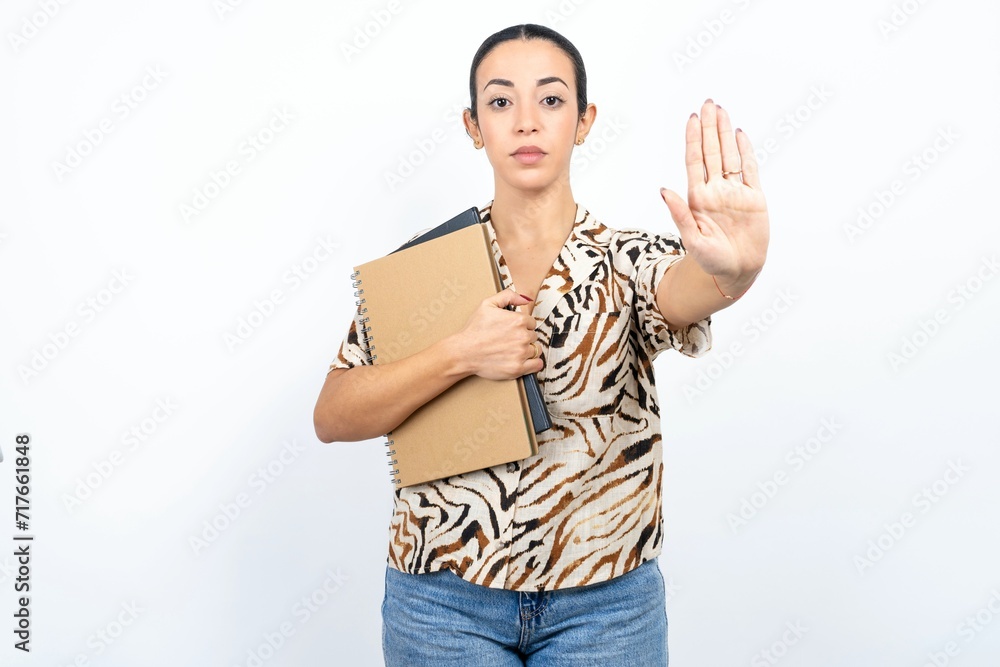 Beautiful young woman doing stop sing with palm of the hand. Warning expression with negative and serious gesture on the face. Beautiful young woman doing stop sing with palm of the hand. Warning expression with negative and serious gesture on the face.