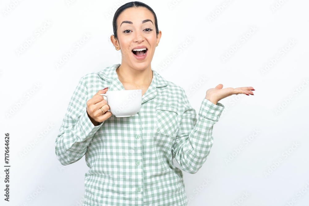 Cheerful cheery optimistic Beautiful young woman wearing green plaid pyjama holding two palms copy space Cheerful cheery optimistic Beautiful young woman wearing green plaid pyjama holding two palms copy space