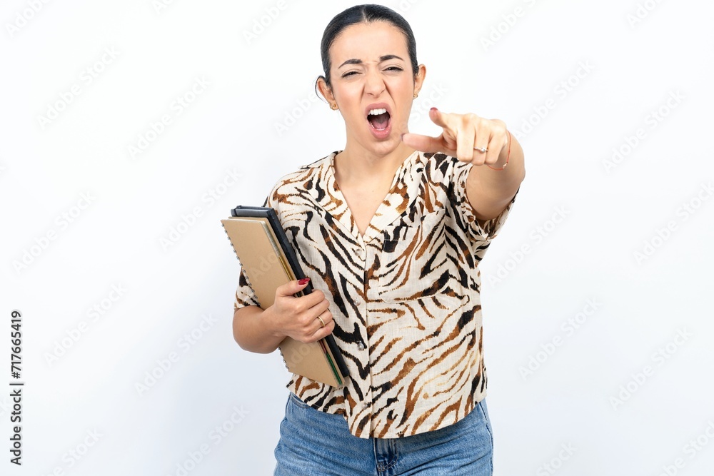 Fototapeta premium Beautiful young woman pointing displeased and frustrated to the camera, angry and furious ready to fight with you.