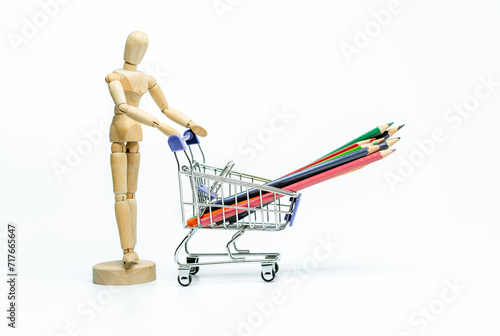 Wooden doll with shopping cart on white background. business or creative concept © joeycheung