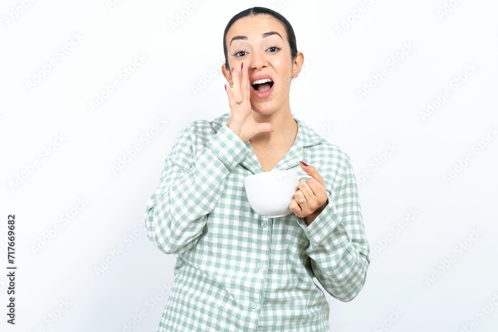 Beautiful young woman wearing green plaid pyjama shouting excited to front. Beautiful young woman wearing green plaid pyjama shouting excited to front.