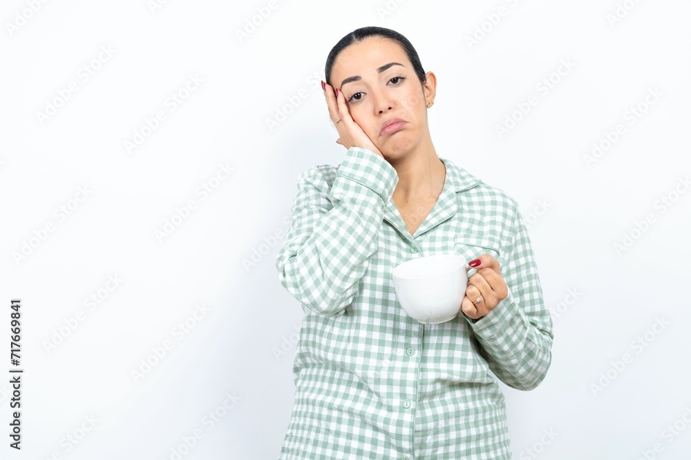 Beautiful young woman wearing green plaid pyjama Tired hands covering face, depression and sadness, upset and irritated for problem Beautiful young woman wearing green plaid pyjama Tired hands covering face, depression and sadness, upset and irritated for problem