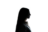 The silhouette of a woman stands enigmatic against a starkly lit white backdrop, her features obscured in shadow, evoking a sense of mystery.