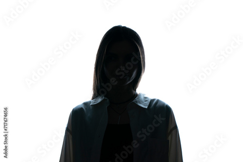 The silhouette of a woman stands enigmatic against a starkly lit white backdrop, her features obscured in shadow, evoking a sense of mystery.