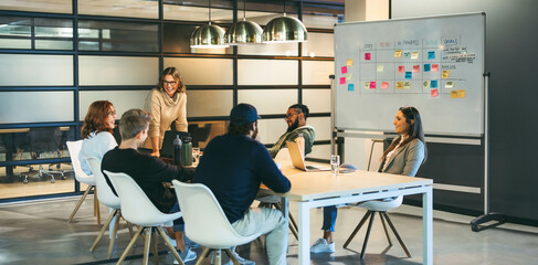Successful teamwork in a diverse office: Colleagues smiling and talking in a productive meeting