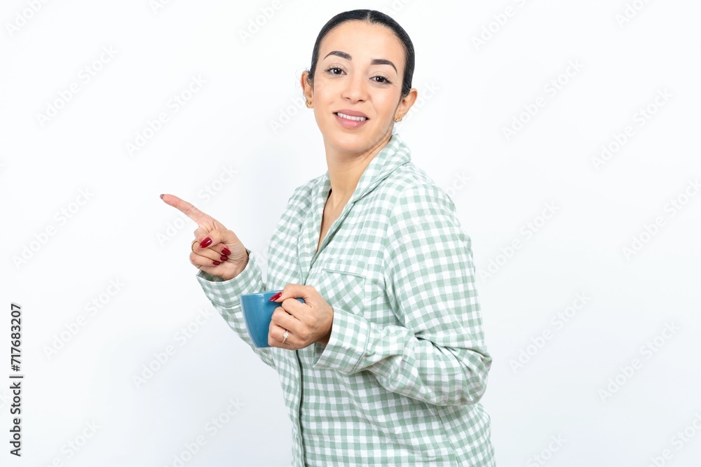 Profile photo of Beautiful young woman wearing green plaid pyjama and holding a cup indicate finger empty space offer Profile photo of Beautiful young woman wearing green plaid pyjama and holding a cup indicate finger empty space offer