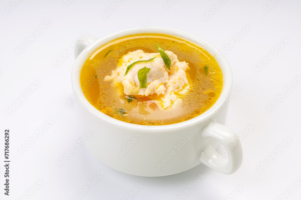 Business lunch. Soup. Chicken broth in a white bowl on a white background Business lunch. Soup. Chicken broth in a white bowl on a white background