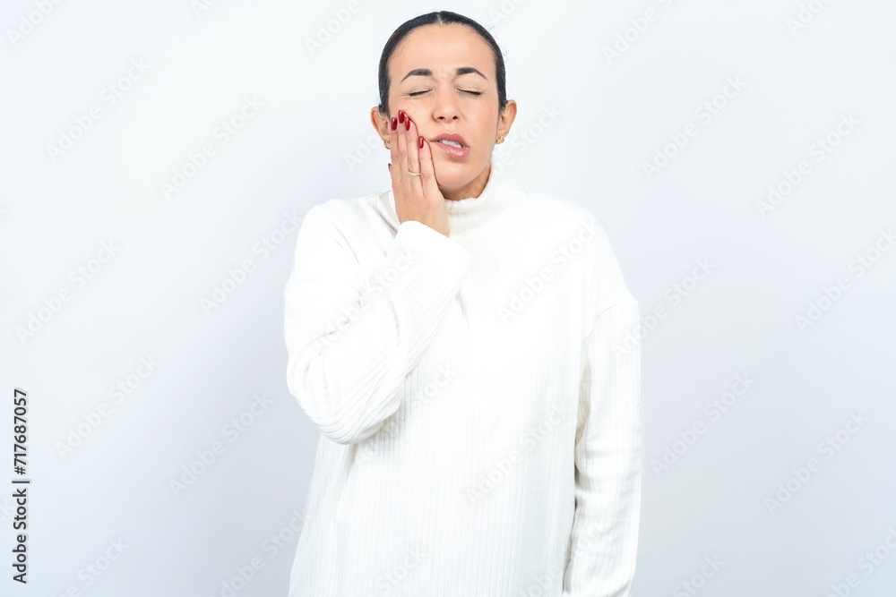 Young beautiful woman wearing white turtleneck sweater with toothache Young beautiful woman wearing white turtleneck sweater with toothache