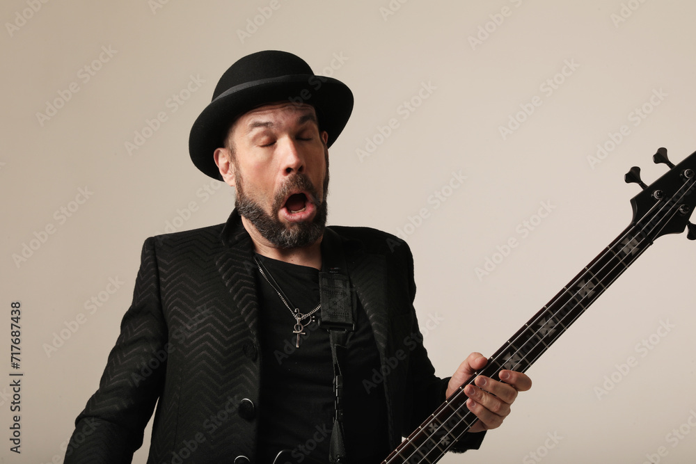 Rock musician. A man with black hat and electric guitar poses at the studio. Rock musician. A man with black hat and electric guitar poses at the studio.