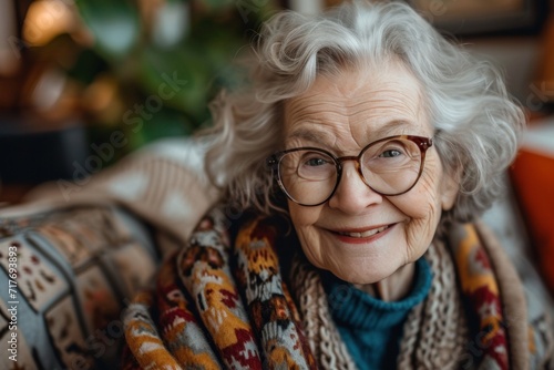 elderly female with glasses smiling while sitting on couch
