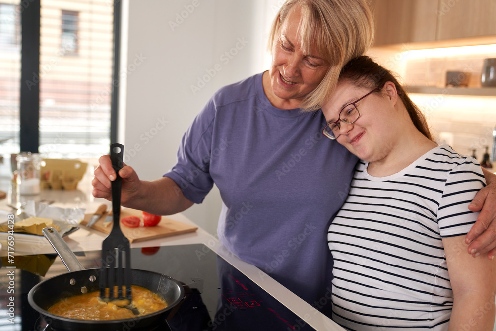 Down syndrome woman and her mother preparing breakfast together Down syndrome woman and her mother preparing breakfast together