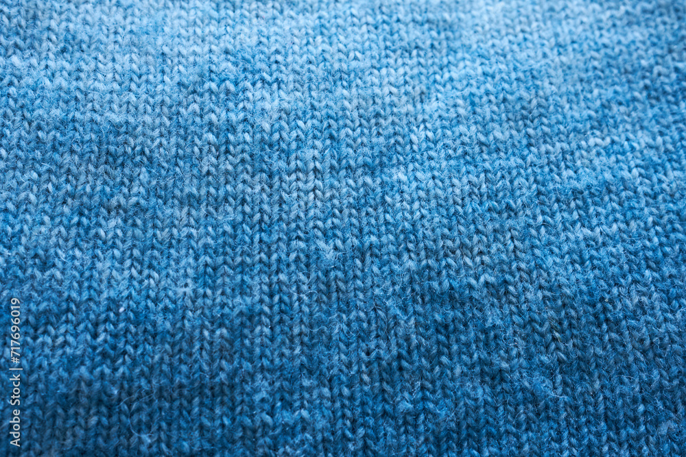Blue knitted fabric as a background. Close-up image. Blue knitted fabric as a background. Close-up image.