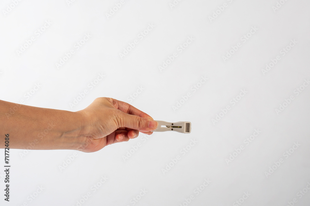 Close up of clothes peg in hand on white background Close up of clothes peg in hand on white background