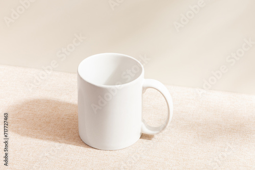 White mug isolated on wood background. Drinking water. White mug. Beverage. Fabric surface. Simplicity. Minimalist object. Space for text. Mockup. Ceramic. Cup of coffee. Morning time.