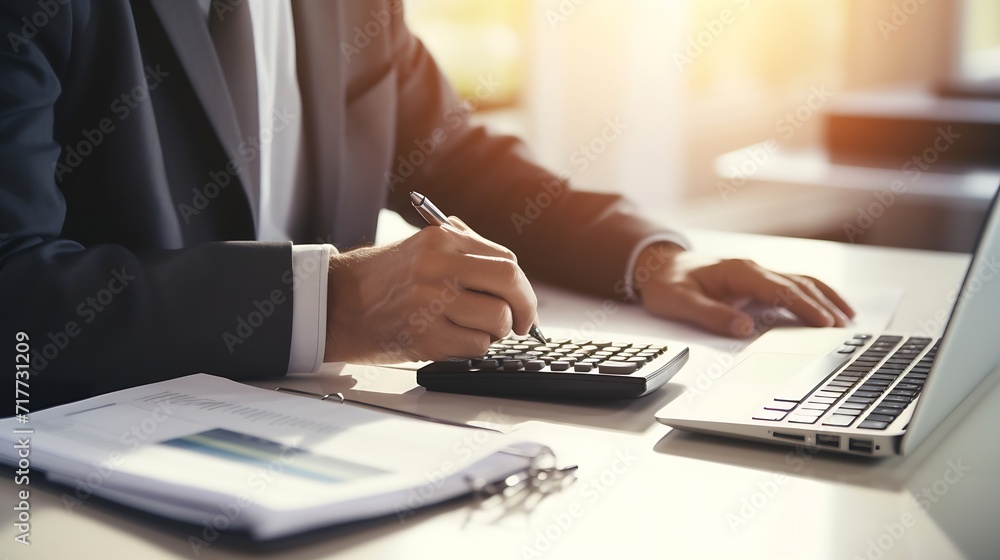 Generative AI : businessman working on desk office with using a calculator to calculate the numbers Generative AI : businessman working on desk office with using a calculator to calculate the numbers