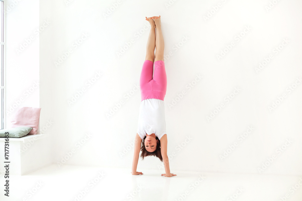 Slim woman doing balancing handstand asana Slim woman doing balancing handstand asana