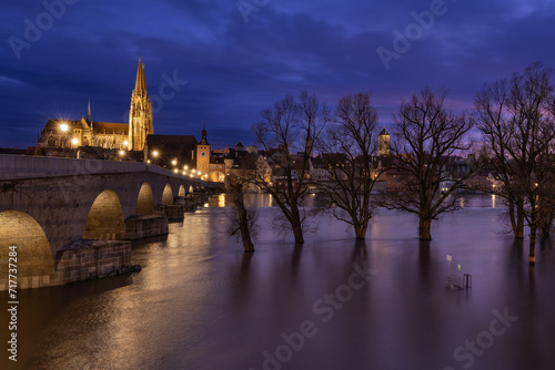 Regensburg in Bayern mit der steinernen Br  cke bei Hochwasser zur blauen Stunde