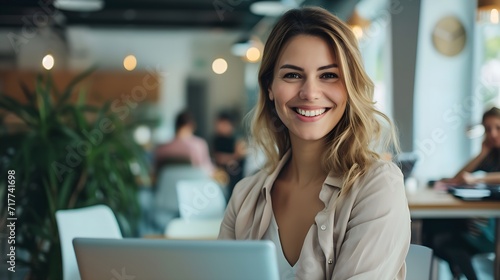 Smiling woman in office using laptop