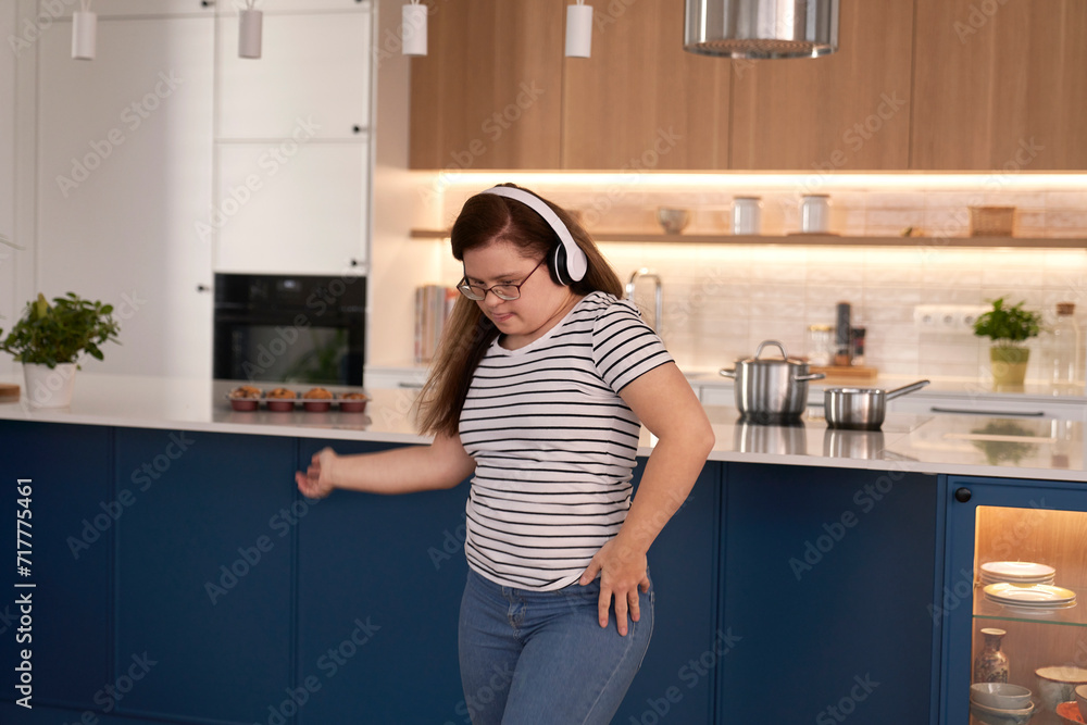 Down syndrome woman using headphones and dancing in the living room Down syndrome woman using headphones and dancing in the living room
