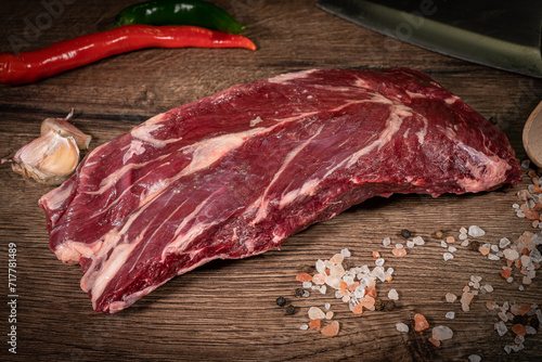 Side view Close up denver Steak, Flank steak, cut near denver alternative beef steak and a cleaver butcher meat knife a rustic metall background selective focus