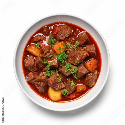 A plate with Goulash on a white plate top view isolated on a white background © ANILCHANDRO