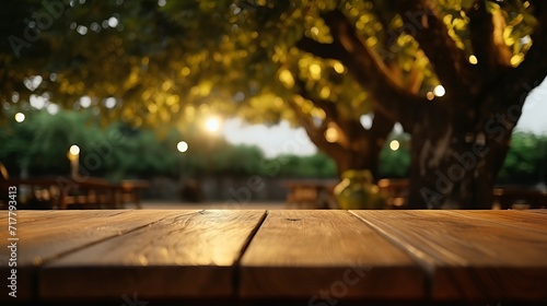 title. empty wood table with decorative outdoor string lights hanging on tree at night 