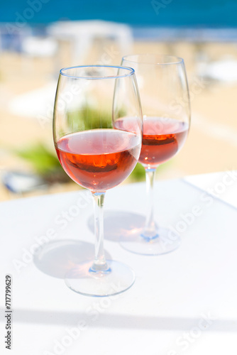 Two glasses of rose wine against blue water and sea