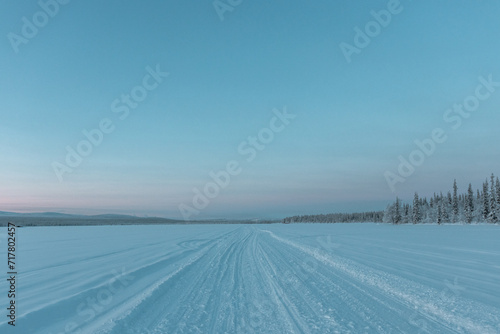 Schneemobilstrasse auf einem gefrorenen See im Schwedischen Lappland, Kiruna photo
