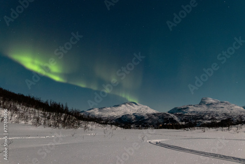 Dynamische U-förmiges Polarlicht über den schneebedeckten Bergen in Norwegen, Narvik