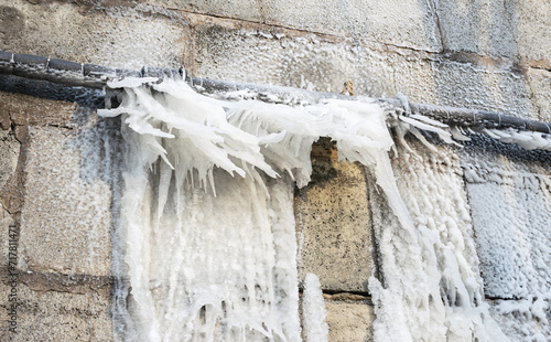 Frozen water after burst from a pipe at the winter.