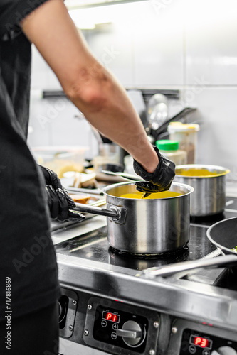 Chef hands cooking cheese sauce in the restaurant kitchen